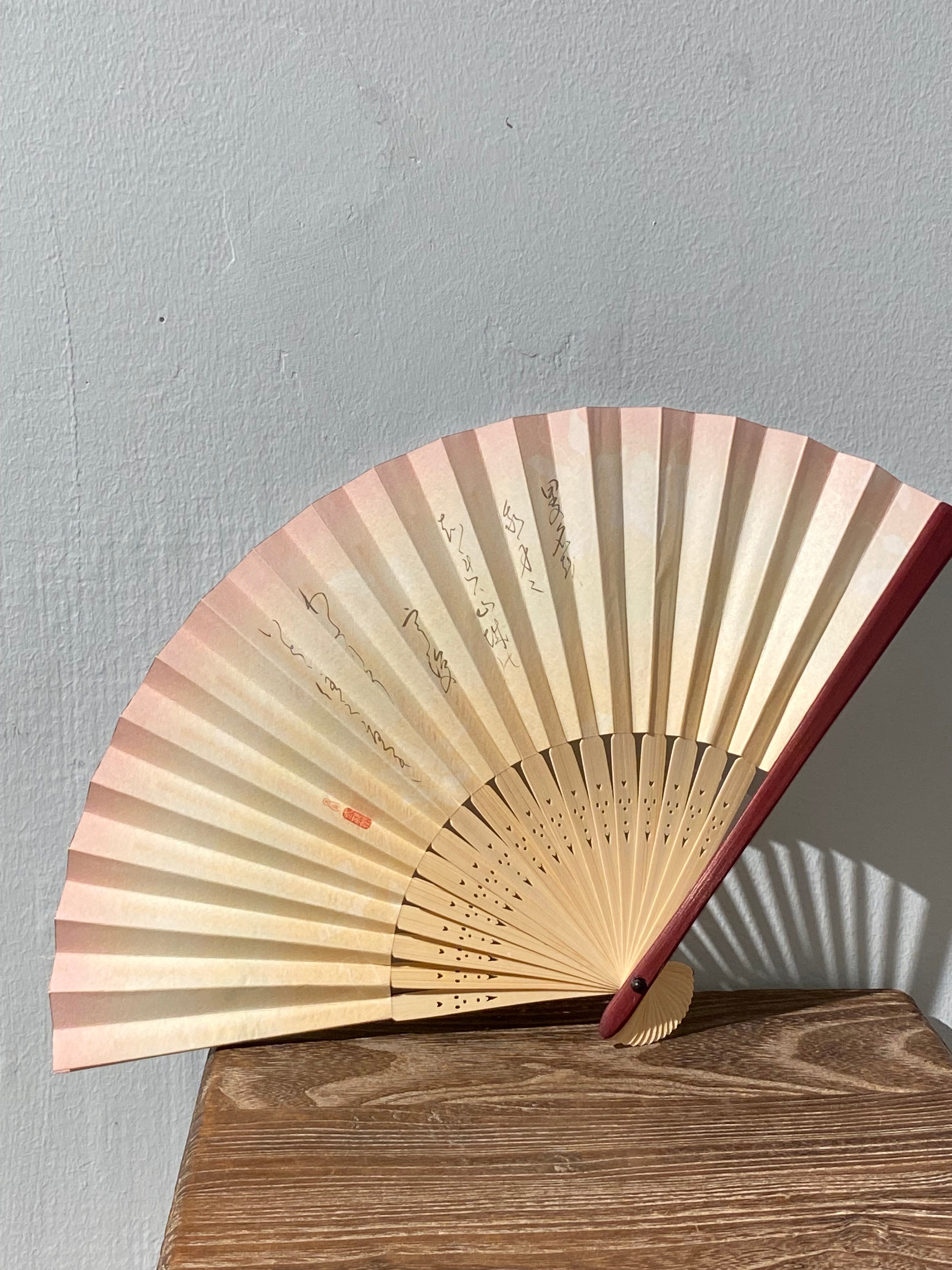 Unique fan with pink border and Japanese characters.