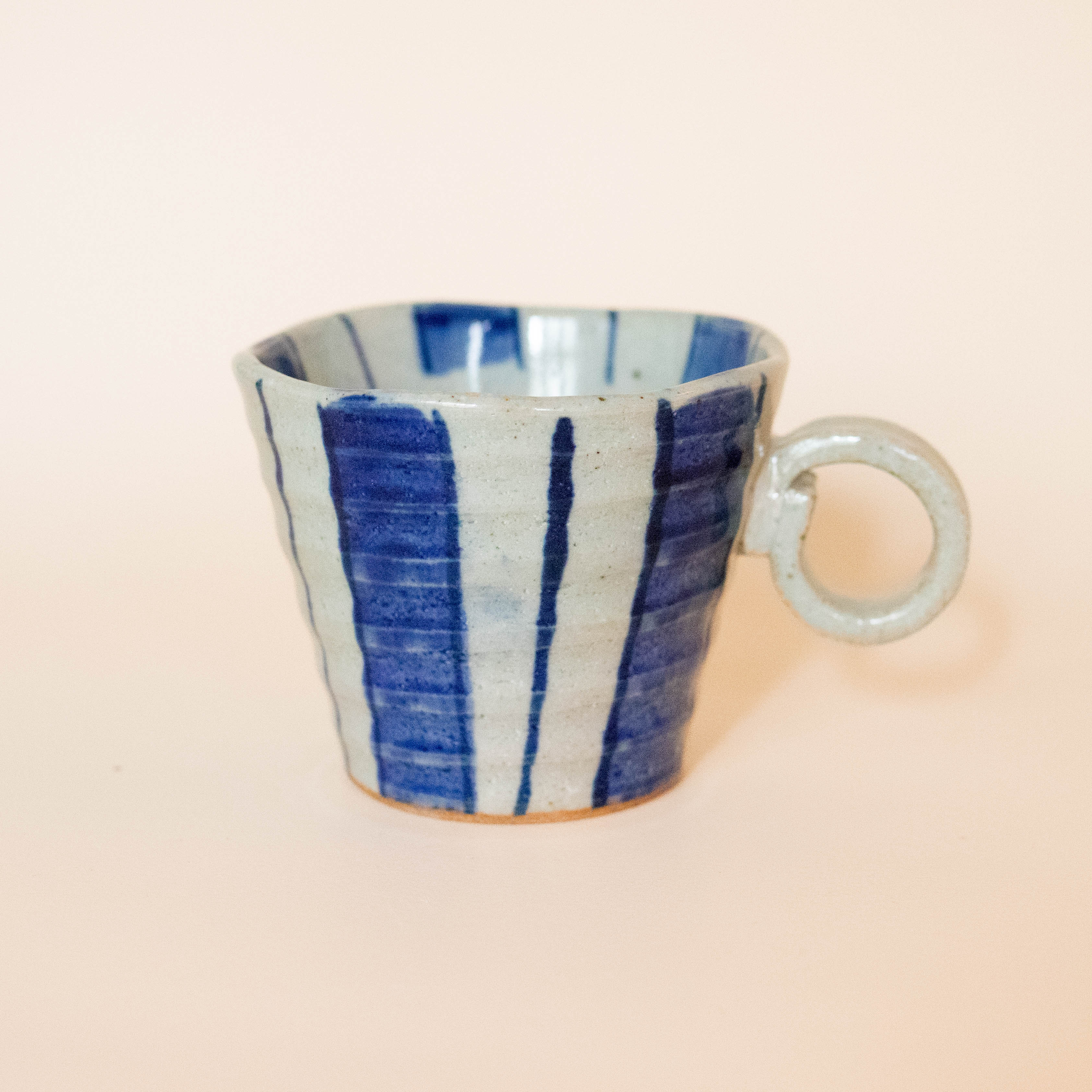 Ceramic cup with wide stripes and round handle