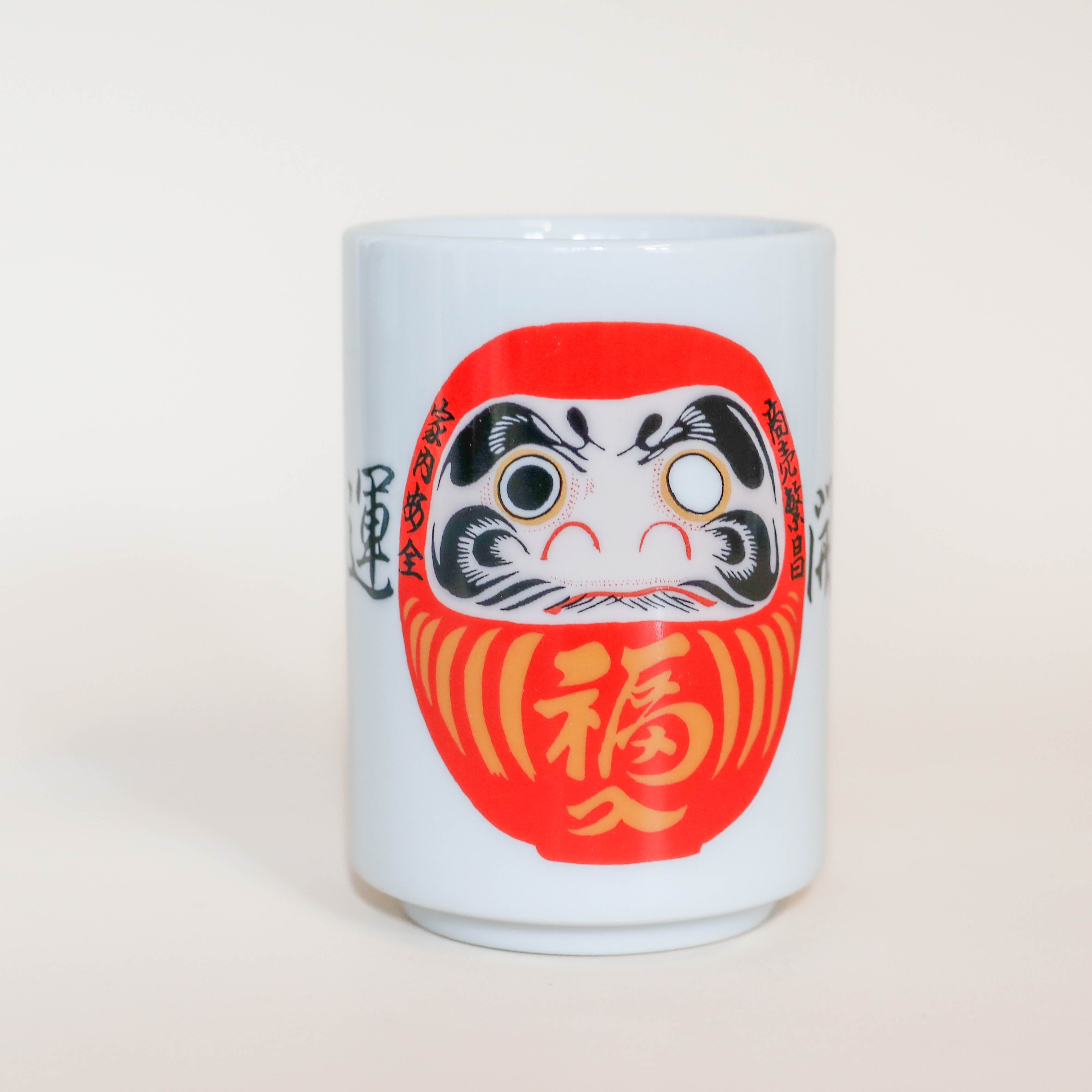 Kop med rød Daruma