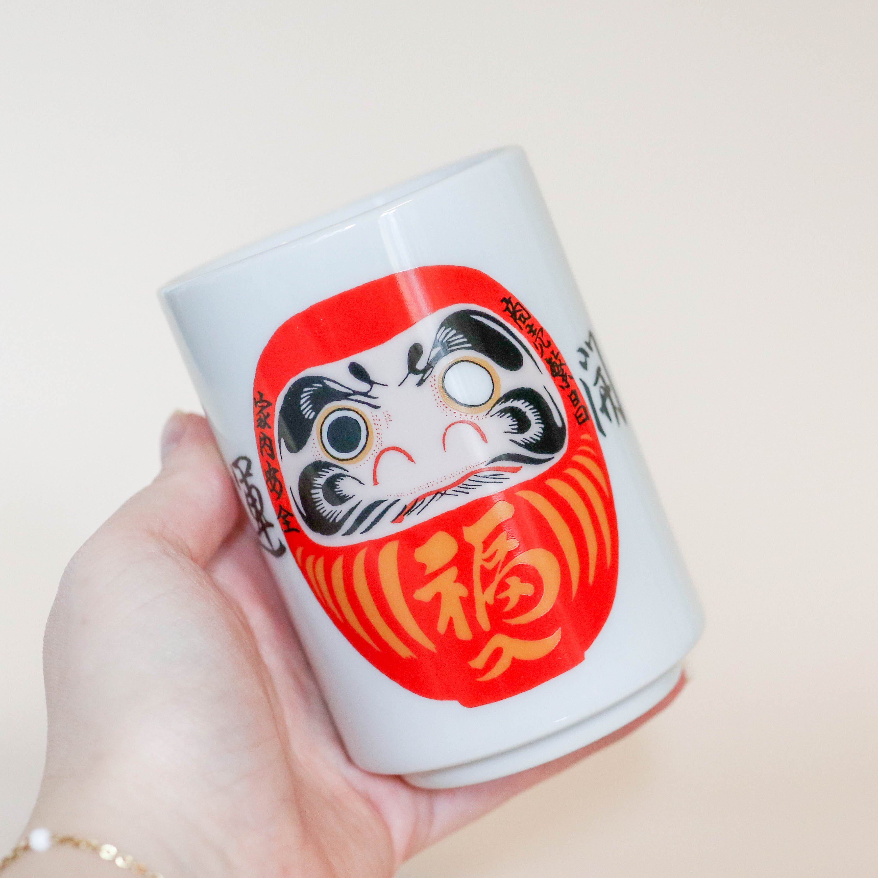 Kop med rød Daruma