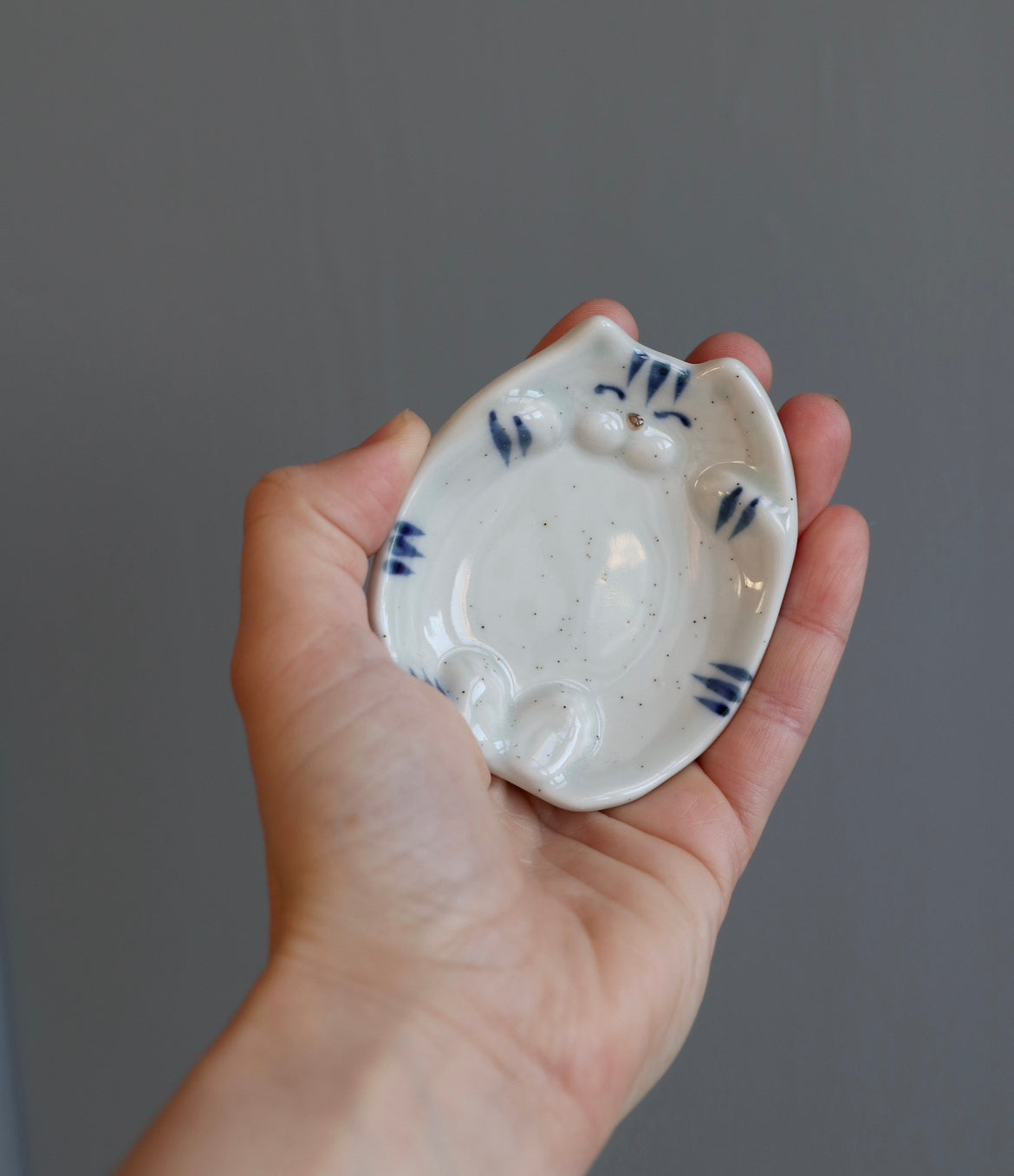 Small bowl with a cat lying on its back