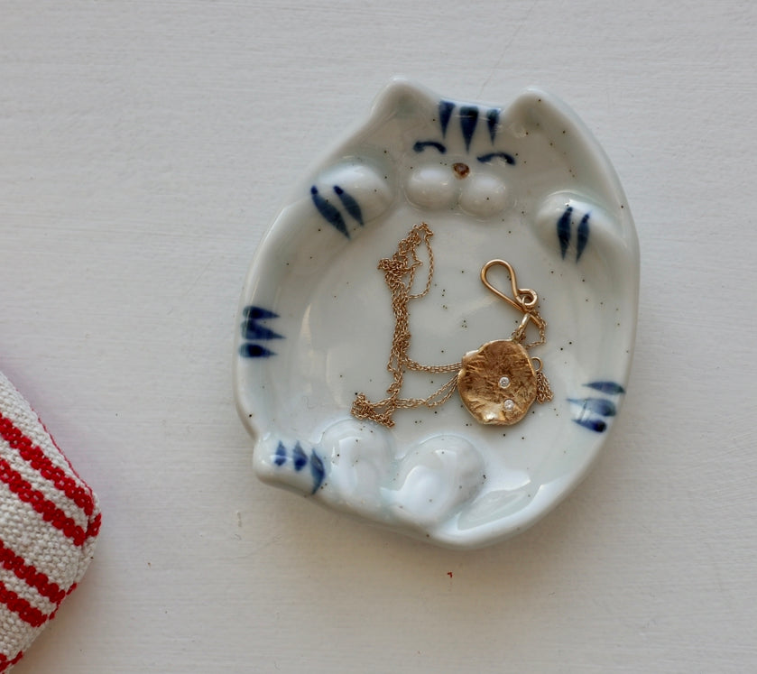 Small bowl with a cat lying on its back